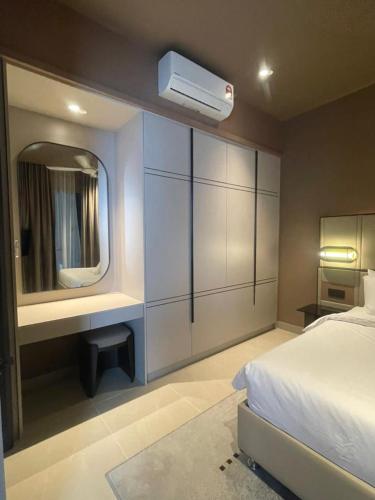 a bedroom with a white bed and a mirror at Antara Genting by Enigma 2BR, Mid Floor in Genting Highlands
