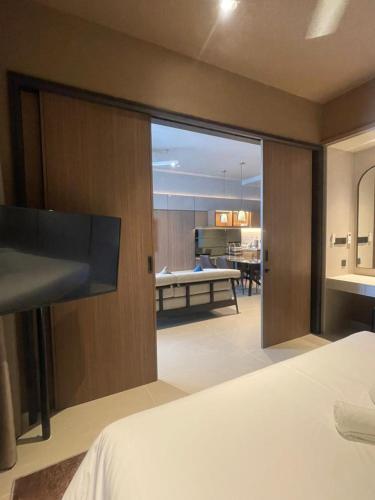 a bedroom with a bed and a view of a living room at Antara Genting by Enigma 2BR, Mid Floor in Genting Highlands