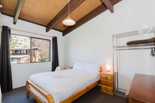 Alpha Centauri - 8 - 39 Gippsland Street في جيندابين: غرفة نوم بها سرير ونافذة