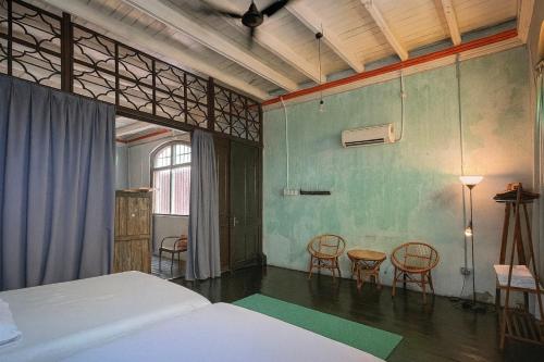 una camera da letto con un letto, due sedie e un tavolo di CHCH by LEJU a Malacca