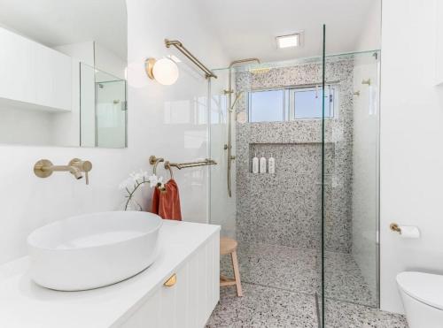 a bathroom with a white sink and a shower at The Sand Box in Kingscliff