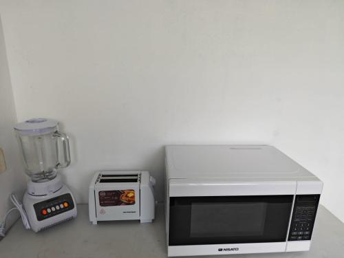 a kitchen counter with a blender and a microwave at Casa Little Italy in Boquerón