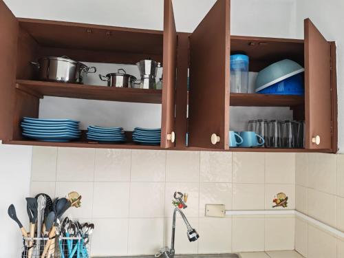 a kitchen with brown cabinets with plates and utensils at Casa Little Italy in Boquerón