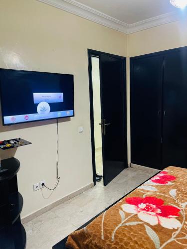 a bedroom with a flat screen tv on the wall at Résidence TPM in Casablanca