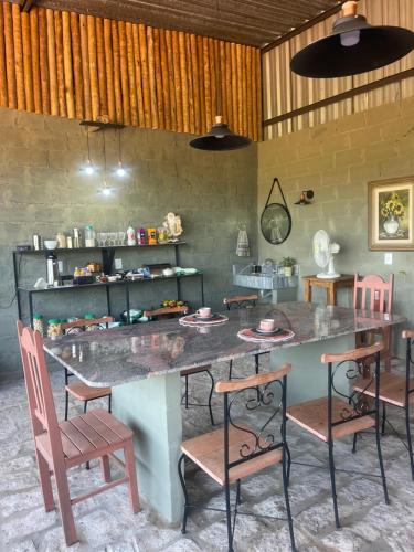 una cucina con un grande tavolo e sedie di Pousada Flat Royal Suíte com varanda e rede a Itapecerica