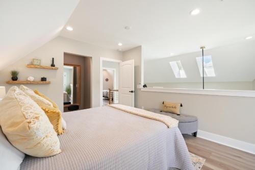 una camera da letto bianca con un letto e una sedia di River Lofts - Onyx & Catawba Cottages a Hickory