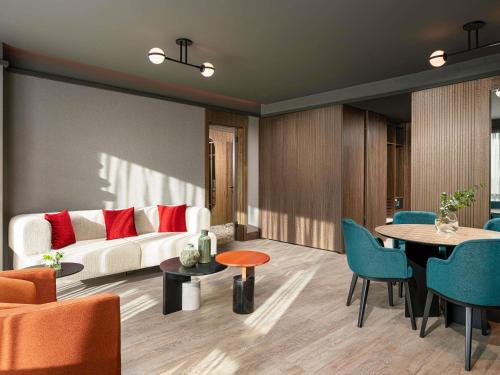 un soggiorno con un divano, un tavolo e delle sedie di Mövenpick Hotel Istanbul Marmara Sea a Istanbul