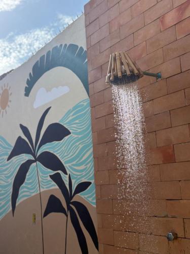 ピアサブスにあるCasa de Praia, Onda Serenaの壁画のあるレンガの壁の横にあるほうき