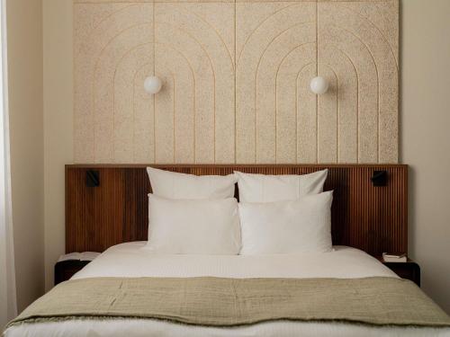 Un pat sau paturi într-o cameră la Hôtel Fort St Laurent Lyon - Handwritten Collection