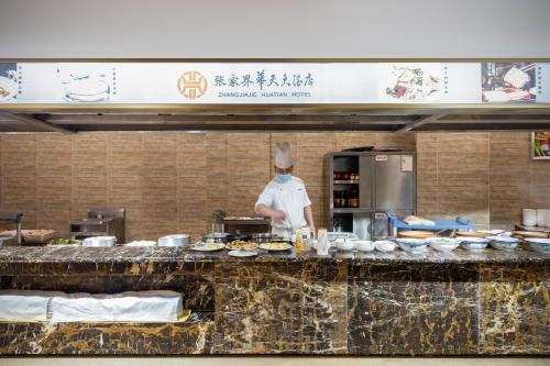 um chef de cozinha a preparar comida em King Maker Grand Hotel-At the Gate of Tianmen Peak Cableway em Zhangjiajie