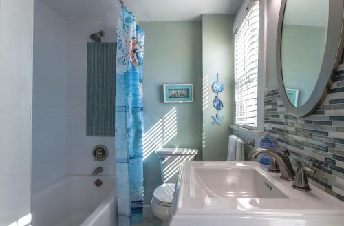 a bathroom with a sink and a tub and a mirror at 1BR 1BA NorthStar Bungalow. Just Steps to the beach and the bay. in St Pete Beach