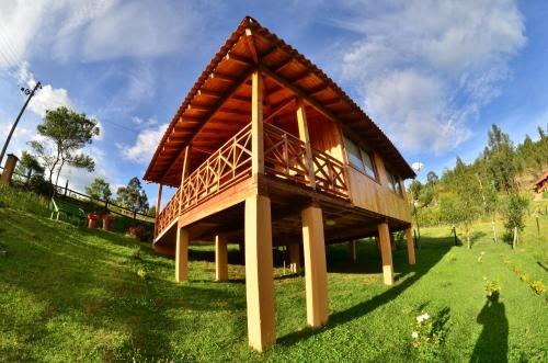 ein kleines Haus mit Dach auf einem grünen Feld in der Unterkunft Cabaña Colibri in Paipa