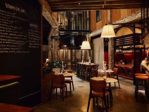 a restaurant with tables and chairs and a menu at Hotel Woolstore 1888, Sydney - Handwritten Collection in Sydney