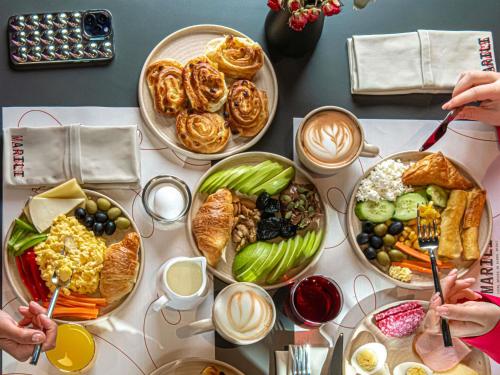 a table with many plates of food on it at ibis Tbilisi City in Tbilisi City