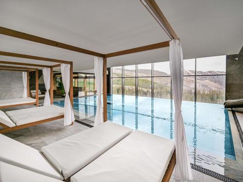 Schlafzimmer mit Poolblick in der Unterkunft Swissôtel Damian Jasna in Demänovská Dolina