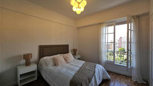 Un dormitorio con una cama y una ventana grande. en El paraíso, en Mar del Plata
