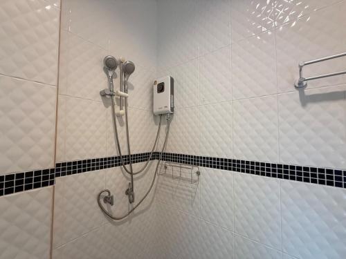 eine Dusche im Bad mit schwarzen und weißen Fliesen in der Unterkunft Serene Jungle Stay House-Very Central- in Ko Phangan