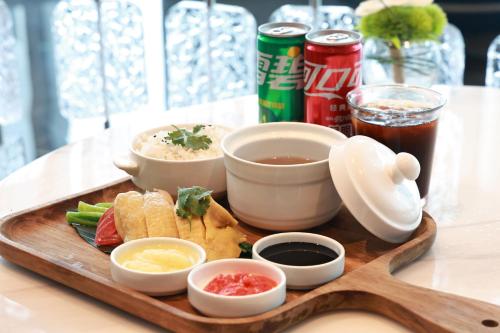 Ein Tablett mit Essen auf einem Tisch, dazu Schüsseln und Getränke. in der Unterkunft Crowne Plaza Taizhou City Center by IHG in Taizhou