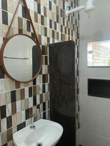 un bagno con lavandino e specchio di Pousada Flat Royal Suíte com varanda e rede a Itapecerica