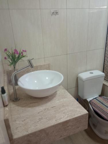 a bathroom with a bowl sink and a toilet at Casa da alegria in Ubatuba
