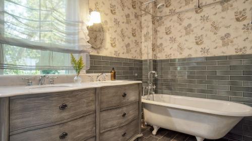 a bathroom with a tub and a sink and a bath tub at Cordelia by AvantStay Amazing Backyard 10mins from Stockbridge in Lee
