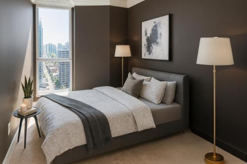 a bedroom with a bed and a large window at Luxury 2-Bedroom Apartment in Coal Harbour with Stunning City Views in Vancouver