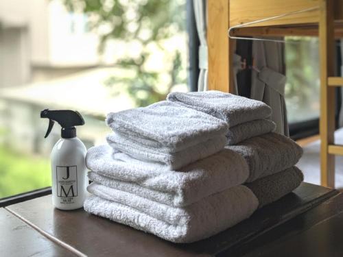 einen Stapel Handtücher auf einem Tisch mit einer Flasche Seife in der Unterkunft Sakura House サクラハウス 高知駅から車で20分-豊かな自然を味わう山の隠れ家 in Kōchi