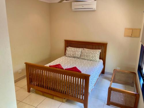 a bedroom with a bed with red pillows on it at Black Wattle Bungalow 30 Lake Bennett in Lake Bennett