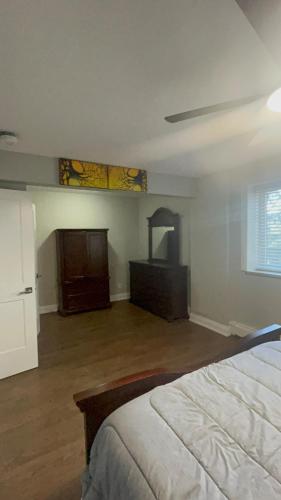 a bedroom with a bed and a dresser and a window at Luxurious Two Bedroom Apartment in Burlington
