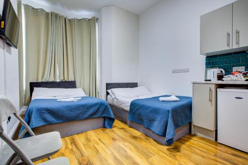 a small room with two beds and a kitchen at London Hamilton Hotel in London