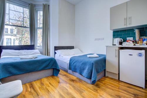 two beds in a small room with a kitchen at London Hamilton Hotel in London