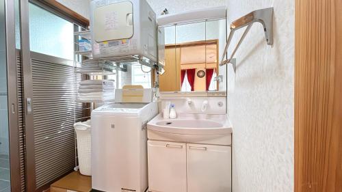 Un pequeño baño con lavabo y lavadora. en Green Lodge, en Yomitan