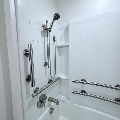 a white bathroom with a shower with a mirror at Modern Downtown SLC in Salt Lake City