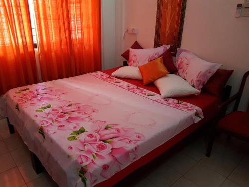 コロンボにあるタンビリ アイランド @ スタッブスのピンクのバラが飾られたベッド