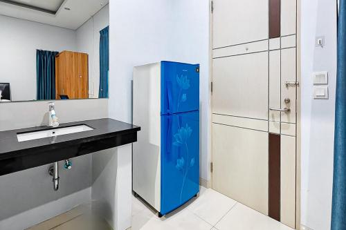 a bathroom with a blue refrigerator next to a sink at Grace House Syariah Cikarang RedPartner in Jatirarangan