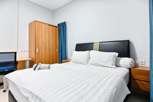 a bedroom with a large white bed with a black headboard at Grace House Syariah Cikarang RedPartner in Jatirarangan