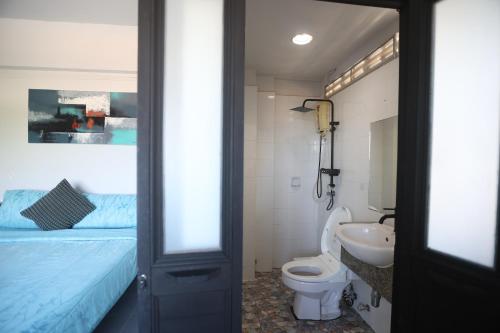 a bathroom with a bed and a toilet and a sink at Funky Crab The River in Krabi
