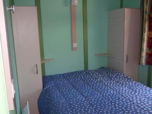 a bedroom with a blue bed in a room at Chalet confortable avec terrasse - 4 personnes - API-1-52-923 in La Chapelle