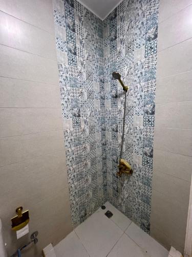 Un baño con ducha con azulejos azules y blancos. en Cozy apartment in down town, en El Cairo