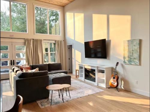 Tubside Tranquility Tobermory Winter Retreat في توبيرموري: غرفة معيشة مع أريكة وجيتار