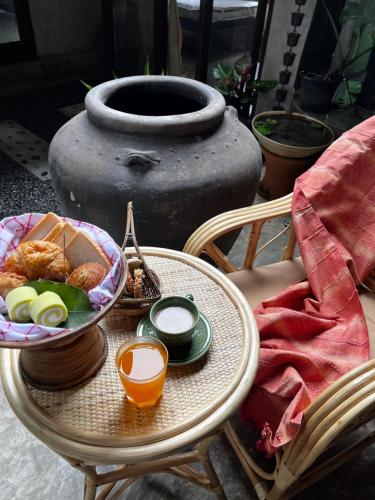 een tafel met een kom eten en een vaas bij Kad Sala Homestay in Ban Nong Wai