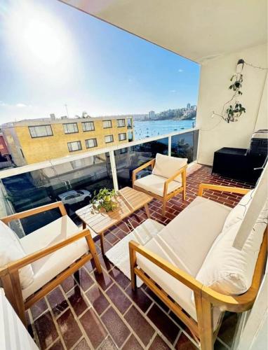 a balcony with couches and a view of a building at Waterfront Bliss Apartment in the Heart of Manly in Sydney