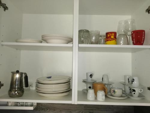 a white cabinet filled with plates and dishes at Casa dos Sonhos Glamping in Lagoa