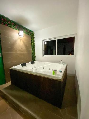 a large bath tub in a bathroom with a window at Hotel Boketto in Tuxpan de Rodríguez Cano