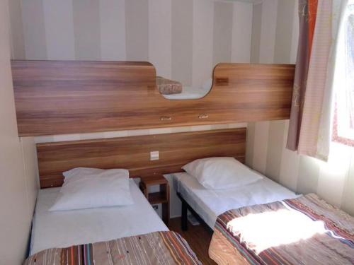 two beds in a small room with twoperate beds at Mobil home 28m² à Saint-Rome-de-Tarn - Terrasse - API-1-52-943 in Saint-Rome-de-Tarn