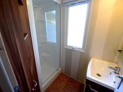 a bathroom with a shower and a sink at Mobil home 28m² à Saint-Rome-de-Tarn - Terrasse - API-1-52-943 in Saint-Rome-de-Tarn