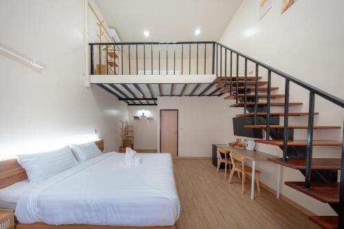 a bedroom with a bed and a spiral staircase at The Nook Hotel in Chiang Mai
