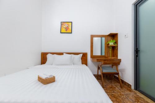 a bedroom with a bed with a mirror and a chair at Hà Giang Homestay - Nhà phố Du lịch Biển Vũng Tàu Gần bãi biển Long cung in Vung Tau