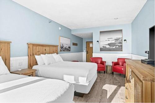 Whispering Pines Lake Views Studio 2 Queen Beds, Heated Pool and Hot Tub في تو هاربورس: غرفة فندقية بسريرين وكراسي حمراء