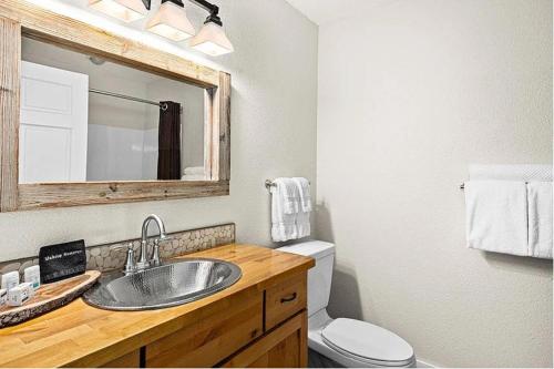 Whispering Pines Lake Views Studio 2 Queen Beds, Heated Pool and Hot Tub في تو هاربورس: حمام مع حوض ومرحاض ومرآة